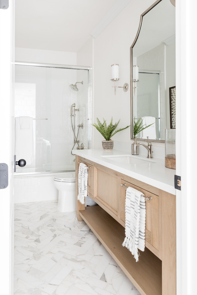 Klassisches Badezimmer mit hellen Holzschränken, Badewanne in Nische, Duschbadewanne, weißer Wandfarbe, Unterbauwaschbecken, weißem Boden, Schiebetür-Duschabtrennung, weißer Waschtischplatte und Schrankfronten im Shaker-Stil in Sacramento