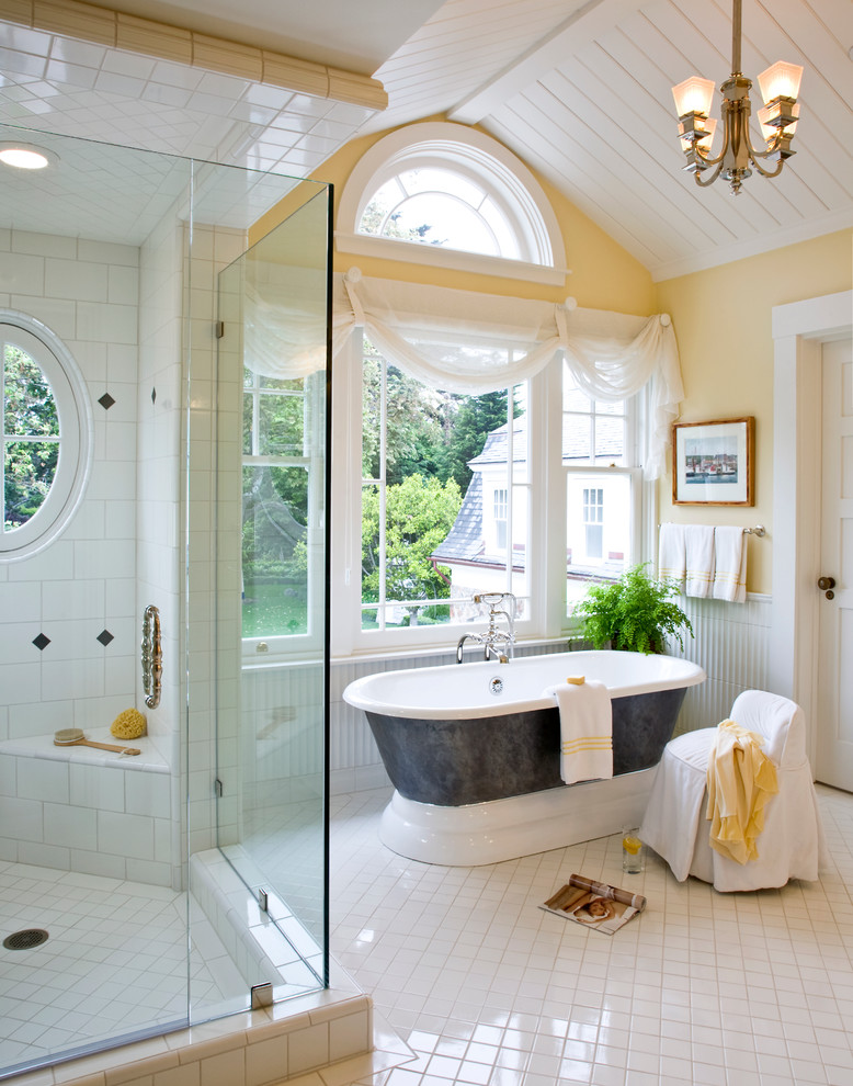 Cette photo montre une salle de bain bord de mer avec une baignoire indépendante et un mur jaune.