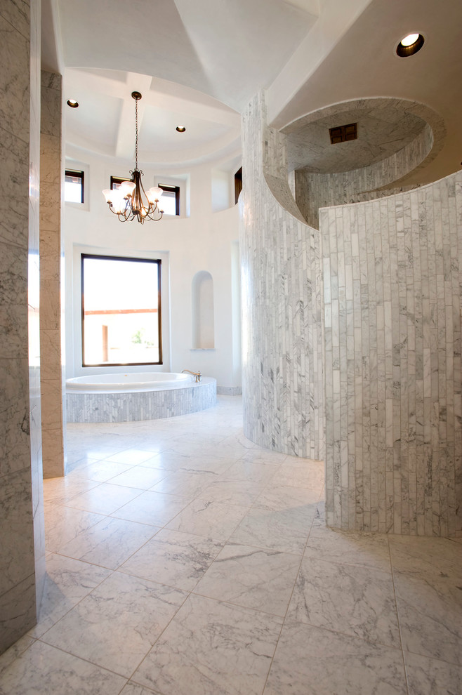 オースティンにある地中海スタイルのおしゃれな浴室 (ドロップイン型浴槽、グレーのタイル) の写真