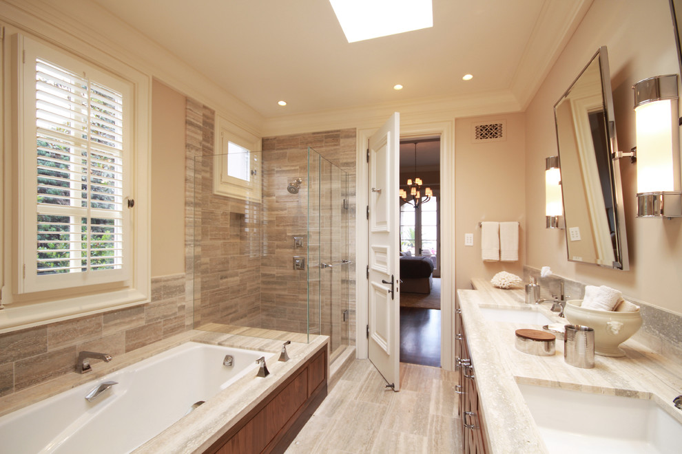 Exempel på ett mellanstort klassiskt en-suite badrum, med ett undermonterad handfat, möbel-liknande, skåp i mellenmörkt trä, bänkskiva i kalksten, ett undermonterat badkar, en hörndusch, en toalettstol med separat cisternkåpa, beige kakel, stenkakel, beige väggar och kalkstensgolv
