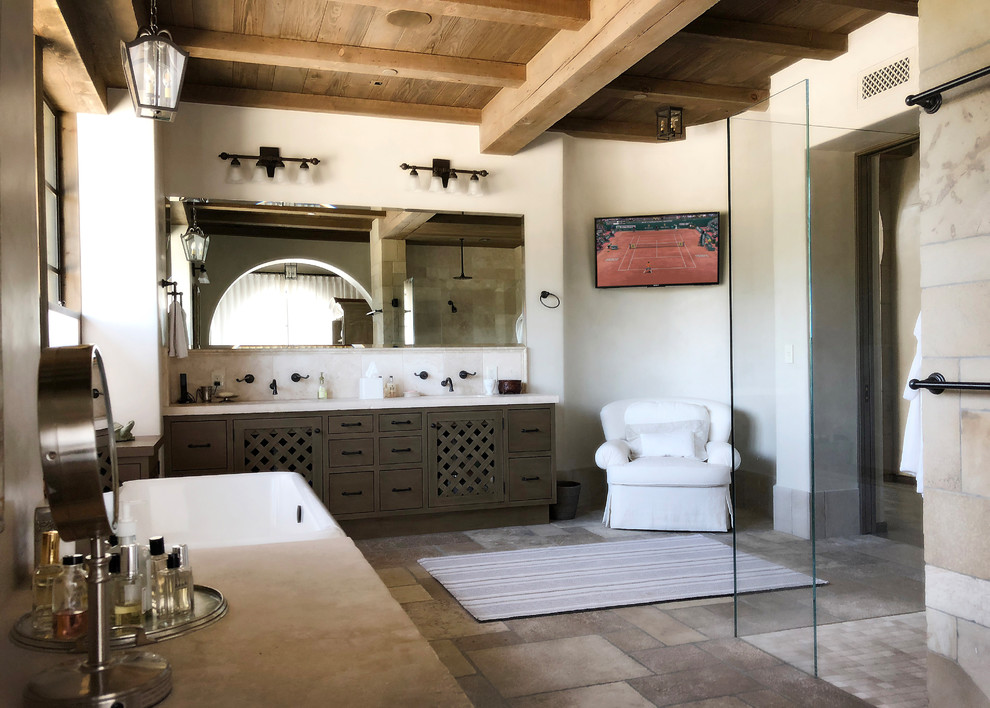 Mediterranes Badezimmer mit flächenbündigen Schrankfronten, grauen Schränken, freistehender Badewanne, bodengleicher Dusche, weißen Fliesen, weißer Wandfarbe, Unterbauwaschbecken, grauem Boden, offener Dusche und weißer Waschtischplatte in Santa Barbara
