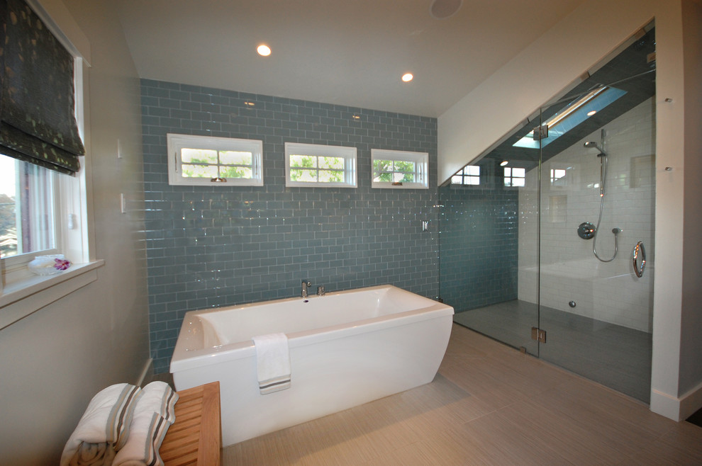 Idéer för funkis badrum, med ett fristående badkar, en kantlös dusch, blå kakel, glaskakel, vita väggar och klinkergolv i porslin
