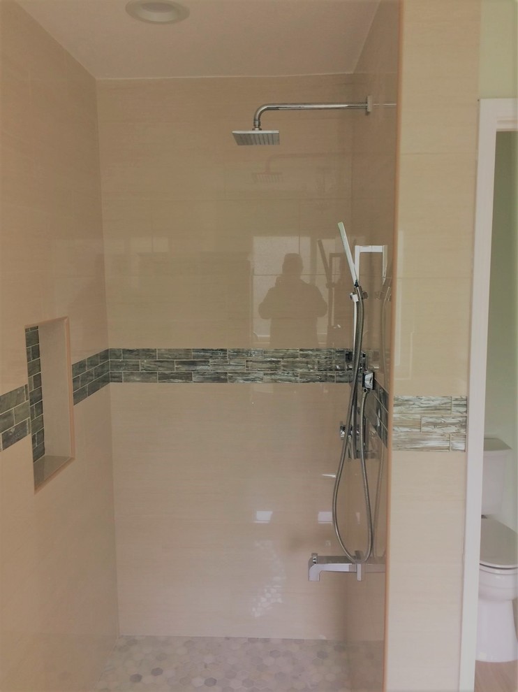 Cette photo montre une salle de bain tendance avec des carreaux de porcelaine, un sol en carrelage de porcelaine et une cabine de douche à porte battante.