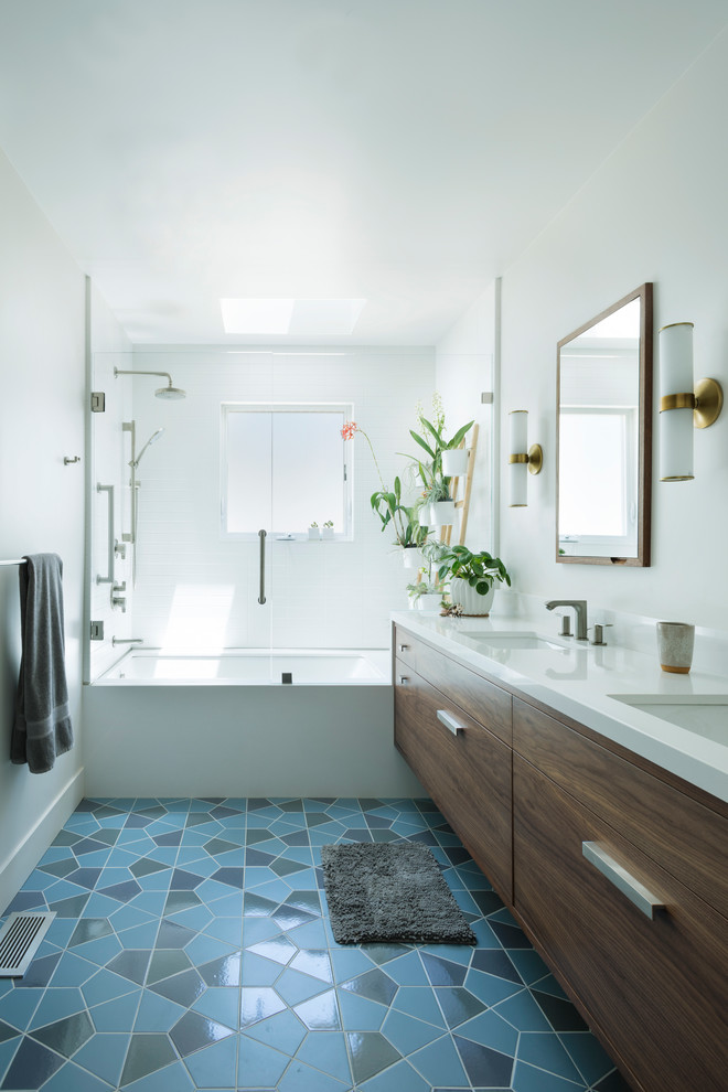 Modern inredning av ett mellanstort vit vitt badrum, med en dusch/badkar-kombination, vita väggar, klinkergolv i keramik, ett undermonterad handfat, bänkskiva i kvarts, blått golv, dusch med gångjärnsdörr, skåp i mörkt trä och ett badkar i en alkov