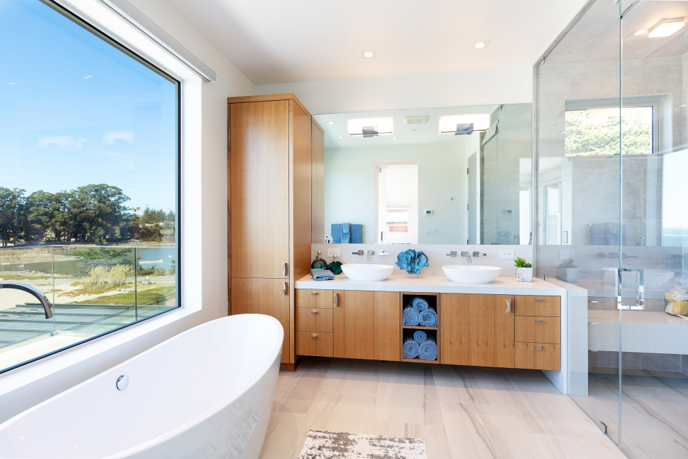 Diseño de cuarto de baño doble contemporáneo con armarios con paneles lisos, puertas de armario de madera oscura, bañera exenta, lavabo sobreencimera, suelo gris y encimeras blancas