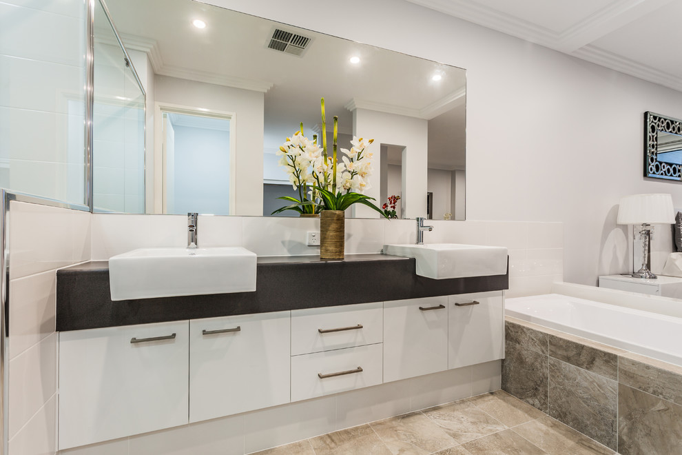 Ispirazione per una stanza da bagno minimal con ante lisce, ante bianche, vasca ad alcova, pareti bianche e lavabo integrato
