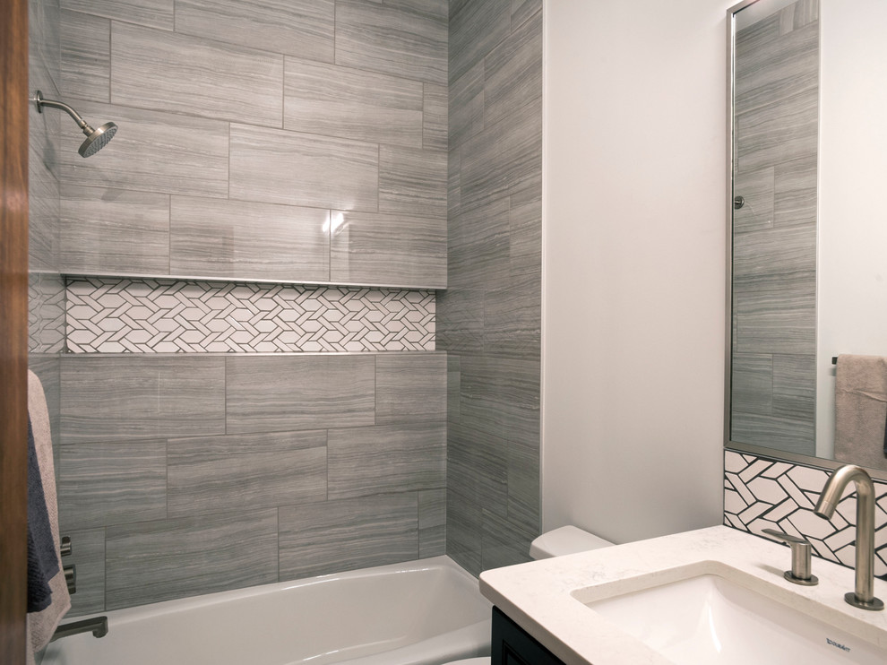 Bathroom - mid-sized transitional 3/4 gray tile and ceramic tile bathroom idea in Albuquerque with dark wood cabinets, a two-piece toilet, white walls, an undermount sink, quartz countertops and white countertops