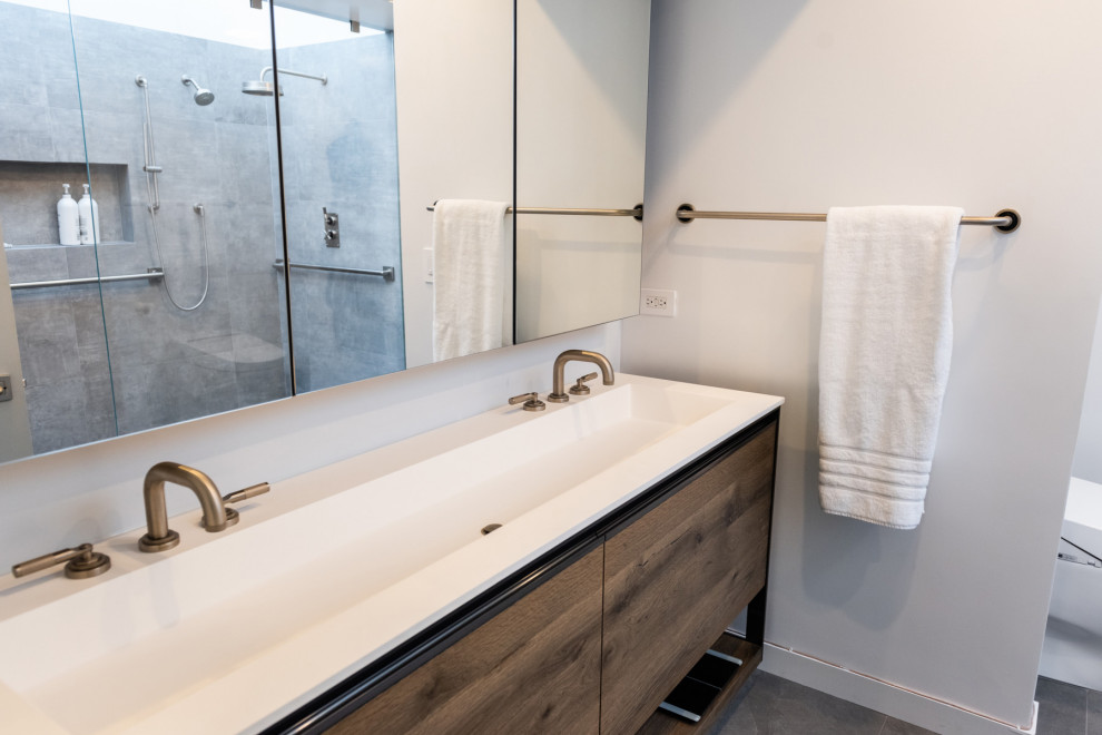 Diseño de cuarto de baño minimalista pequeño con armarios tipo mueble, puertas de armario marrones, bañera encastrada, ducha abierta, bidé, baldosas y/o azulejos grises, paredes blancas, encimera de cuarzo compacto y encimeras blancas