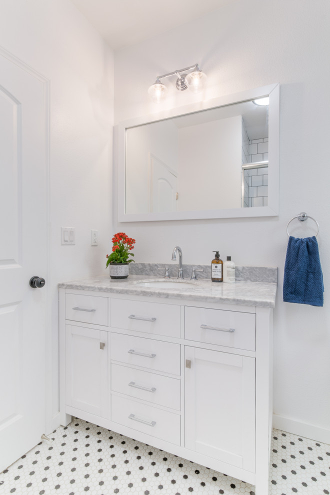 Réalisation d'une petite salle de bain design avec un placard à porte shaker, des portes de placard blanches, WC à poser, un mur blanc, un sol en carrelage de terre cuite, un lavabo encastré, un plan de toilette en marbre, un sol blanc et un plan de toilette gris.