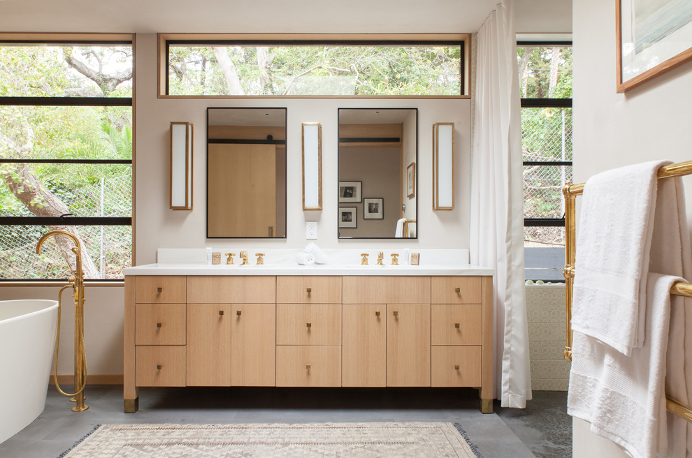 Inredning av ett minimalistiskt en-suite badrum, med släta luckor, skåp i ljust trä och marmorbänkskiva