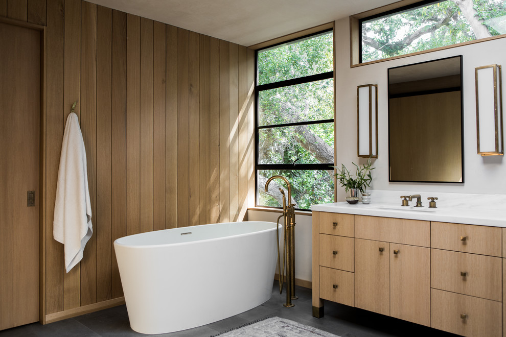 Ispirazione per una stanza da bagno rustica con consolle stile comò, ante in legno chiaro, vasca freestanding e lavabo sottopiano