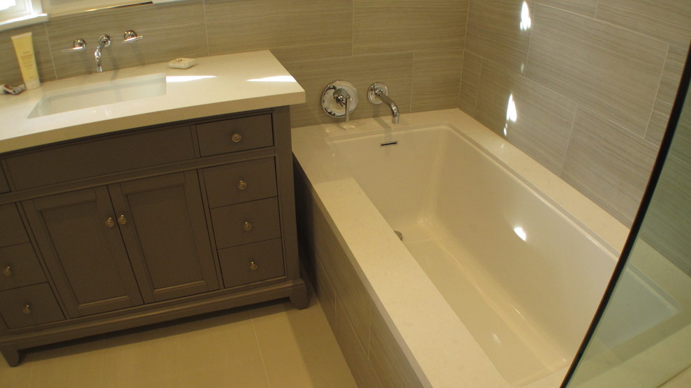 Medium sized contemporary ensuite bathroom in Los Angeles with freestanding cabinets, grey cabinets, a corner bath, a corner shower, a two-piece toilet, porcelain tiles, grey walls, travertine flooring, a submerged sink and engineered stone worktops.