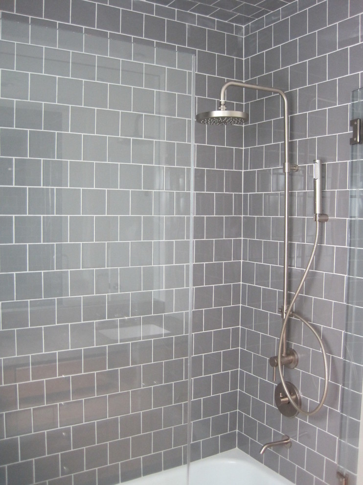 Ispirazione per una stanza da bagno con doccia minimal con doccia ad angolo, piastrelle grigie, piastrelle diamantate e pareti grigie
