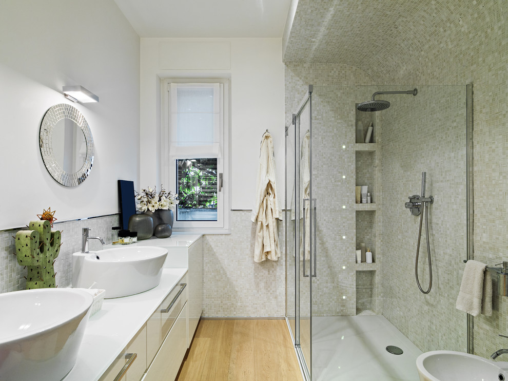 Idéer för funkis vitt badrum, med släta luckor, vita skåp, en kantlös dusch, vit kakel, mosaik, vita väggar, ljust trägolv, ett fristående handfat, beiget golv och dusch med skjutdörr