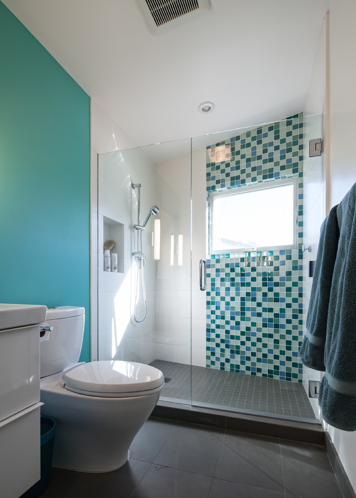 Bild på ett mellanstort 60 tals badrum för barn, med grön kakel, gröna väggar, ett undermonterad handfat, släta luckor, vita skåp, en dusch i en alkov och glaskakel