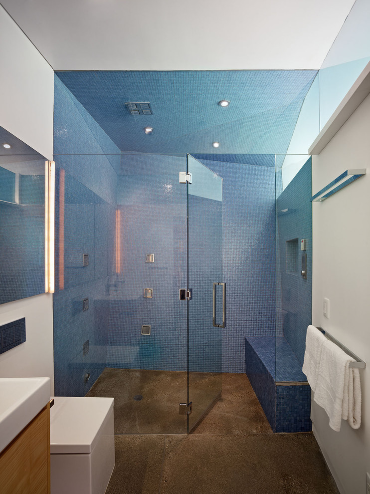 Modernes Badezimmer mit hellbraunen Holzschränken, bodengleicher Dusche, blauen Fliesen, Mosaikfliesen, braunem Boden, weißer Wandfarbe, Trogwaschbecken und Falttür-Duschabtrennung in Los Angeles