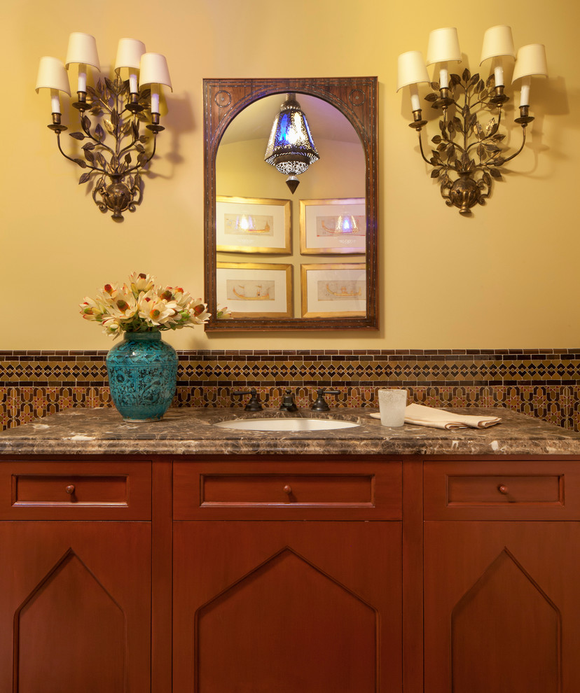 На фото: большая главная ванная комната в средиземноморском стиле с фасадами с утопленной филенкой, фасадами цвета дерева среднего тона, плиткой мозаикой, желтыми стенами, врезной раковиной и столешницей из гранита с
