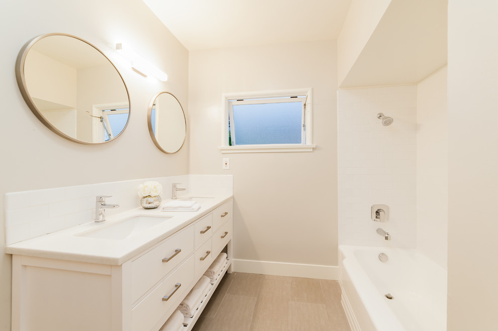 Immagine di una piccola stanza da bagno padronale moderna con vasca/doccia, lavabo sottopiano, top in superficie solida, ante lisce, ante bianche, vasca ad alcova e doccia con tenda