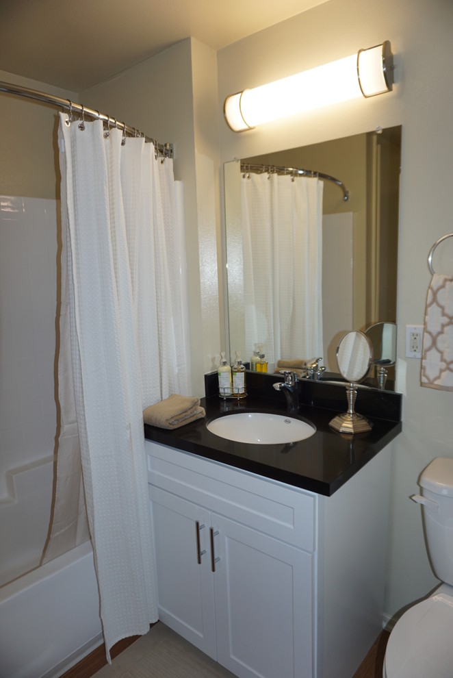 Exemple d'une petite salle de bain principale tendance avec un placard avec porte à panneau encastré, des portes de placard blanches, un combiné douche/baignoire, WC séparés, un mur blanc, un sol en vinyl, un lavabo encastré et un plan de toilette en quartz modifié.