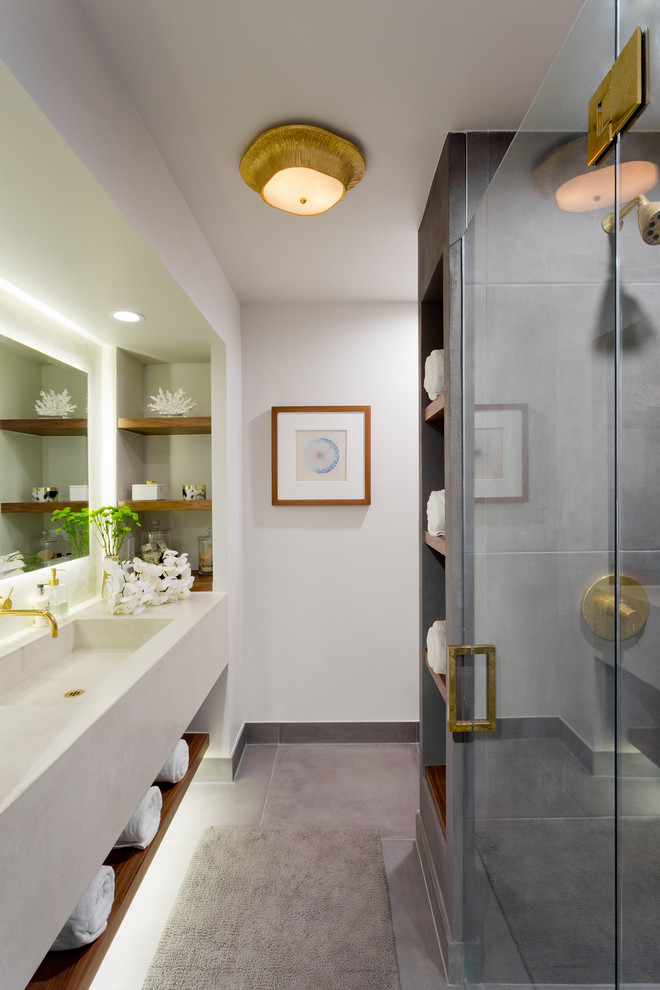 This is an example of a medium sized coastal ensuite bathroom in Los Angeles with an alcove shower, white walls, concrete flooring, an integrated sink, grey floors, a hinged door, open cabinets, medium wood cabinets, beige worktops and limestone worktops.