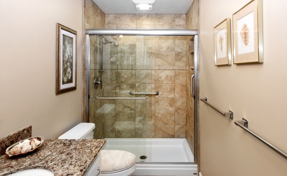 Idéer för att renovera ett mellanstort vintage badrum med dusch, med vita skåp, en dusch i en alkov, en toalettstol med separat cisternkåpa, brun kakel, travertinkakel, beige väggar, ett undermonterad handfat, granitbänkskiva och dusch med skjutdörr