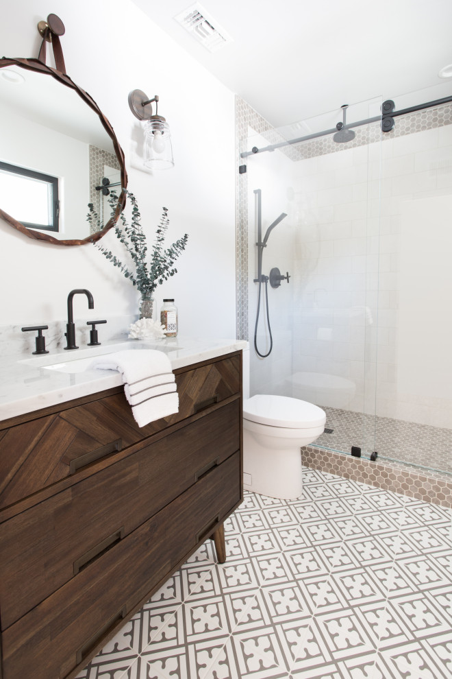 Стильный дизайн: ванная комната среднего размера в стиле неоклассика (современная классика) с плоскими фасадами, темными деревянными фасадами, душем в нише, унитазом-моноблоком, белой плиткой, керамогранитной плиткой, белыми стенами, полом из керамогранита, душевой кабиной, врезной раковиной, разноцветным полом, душем с раздвижными дверями, белой столешницей и мраморной столешницей - последний тренд