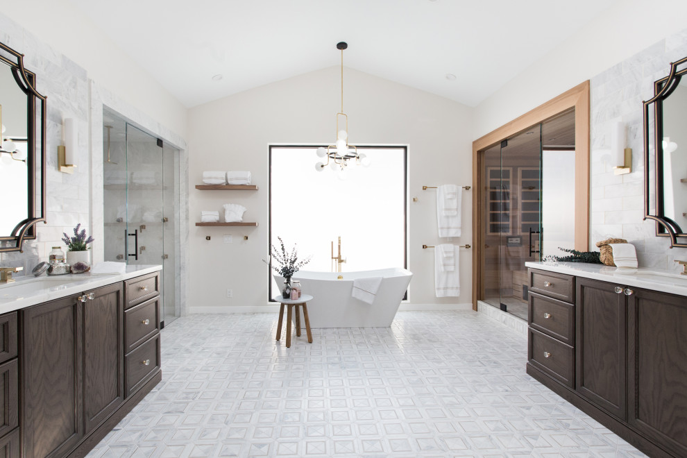 Expansive classic ensuite bathroom in Santa Barbara with shaker cabinets, dark wood cabinets, a freestanding bath, an alcove shower, a one-piece toilet, white tiles, marble tiles, white walls, mosaic tile flooring, a submerged sink, marble worktops, multi-coloured floors, a hinged door and white worktops.