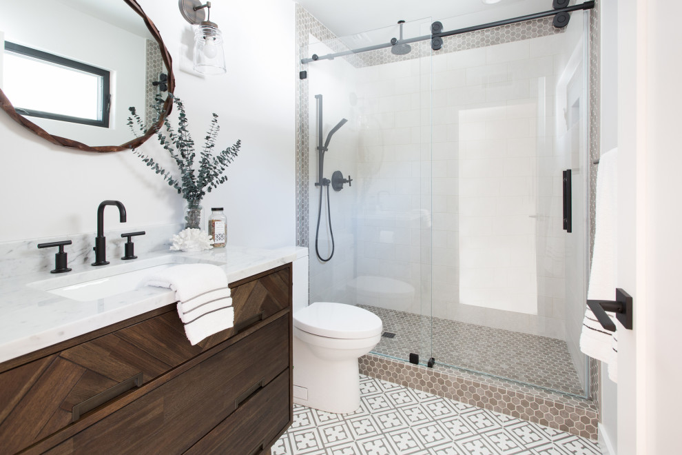 Design ideas for a medium sized traditional shower room bathroom in Santa Barbara with flat-panel cabinets, dark wood cabinets, an alcove shower, a one-piece toilet, white tiles, porcelain tiles, white walls, porcelain flooring, a submerged sink, multi-coloured floors, a sliding door, white worktops and marble worktops.