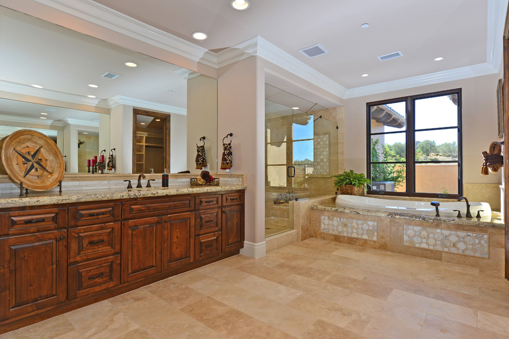 Aménagement d'une très grande salle de bain principale méditerranéenne en bois brun avec un placard avec porte à panneau surélevé, un plan de toilette en granite, une baignoire posée, une douche double et un sol en travertin.