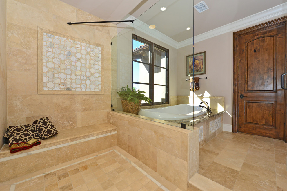Esempio di un'ampia stanza da bagno padronale mediterranea con ante con bugna sagomata, ante in legno scuro, top in granito, vasca da incasso, doccia doppia e pavimento in travertino
