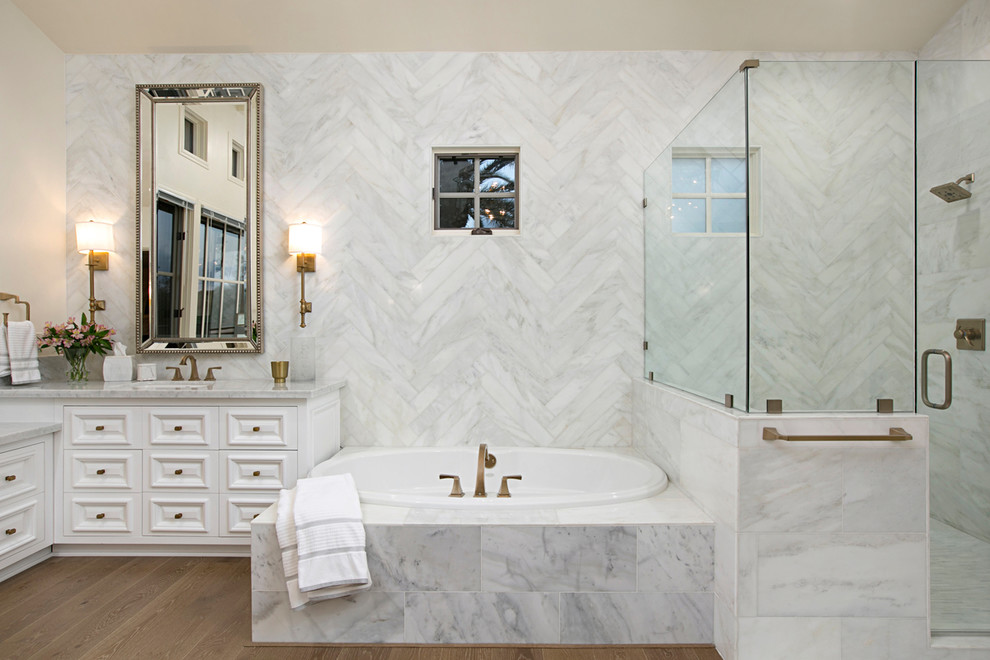 Свежая идея для дизайна: главная ванная комната в средиземноморском стиле с фасадами островного типа, белыми фасадами, накладной ванной, угловым душем, мраморной плиткой, врезной раковиной и мраморной столешницей - отличное фото интерьера