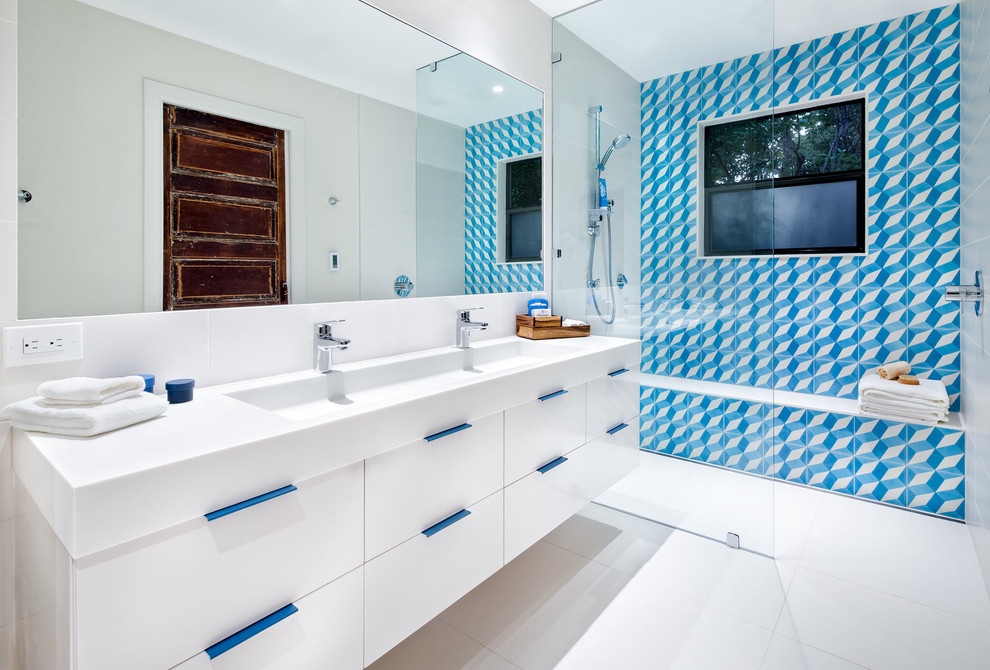 Idéer för att renovera ett funkis en-suite badrum, med släta luckor, vita skåp, vit kakel, cementkakel, vita väggar, ett avlångt handfat och bänkskiva i akrylsten