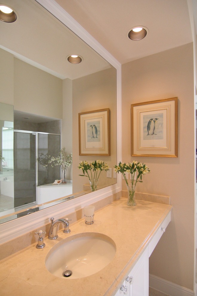 Foto de cuarto de baño principal clásico de tamaño medio con armarios con paneles lisos, puertas de armario blancas, ducha esquinera, paredes beige, lavabo encastrado y encimera de granito