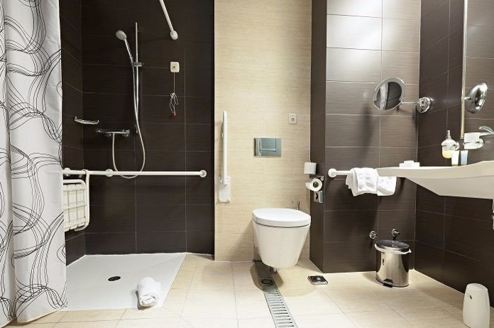 На фото: ванная комната среднего размера в стиле модернизм с открытым душем, инсталляцией, коричневой плиткой, керамической плиткой, бежевыми стенами, полом из керамической плитки, подвесной раковиной, белым полом и открытым душем