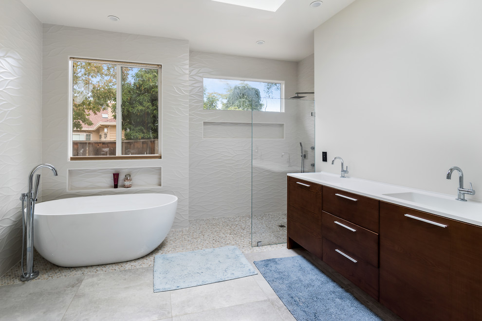 Inspiration för moderna vitt badrum, med släta luckor, skåp i mörkt trä, ett fristående badkar, våtrum, vit kakel, vita väggar, ett integrerad handfat, grått golv och med dusch som är öppen