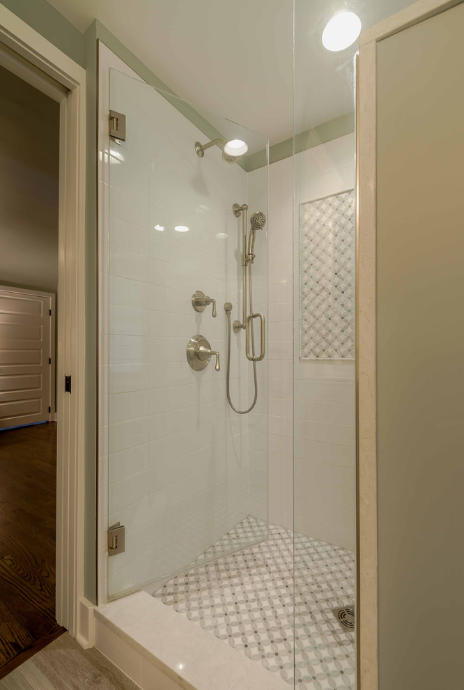 Свежая идея для дизайна: главная ванная комната среднего размера в стиле кантри с фасадами в стиле шейкер, белыми фасадами, душем в нише, раздельным унитазом, белой плиткой, мраморной плиткой, серыми стенами, полом из керамической плитки, врезной раковиной, столешницей из искусственного камня, серым полом, душем с распашными дверями, белой столешницей, зеркалом с подсветкой, тумбой под две раковины, напольной тумбой, потолком с обоями и панелями на стенах - отличное фото интерьера