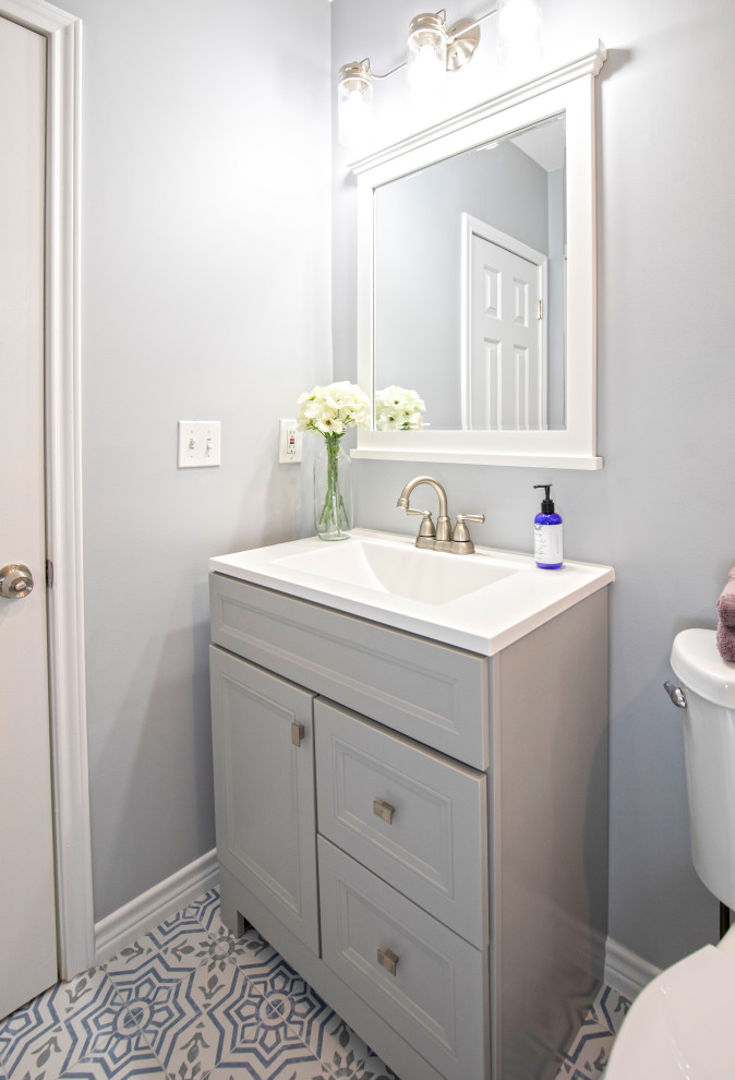Idéer för ett litet lantligt vit badrum med dusch, med möbel-liknande, grå skåp, en dusch i en alkov, en toalettstol med separat cisternkåpa, vit kakel, keramikplattor, blå väggar, klinkergolv i porslin, ett integrerad handfat, bänkskiva i akrylsten, flerfärgat golv och dusch med skjutdörr