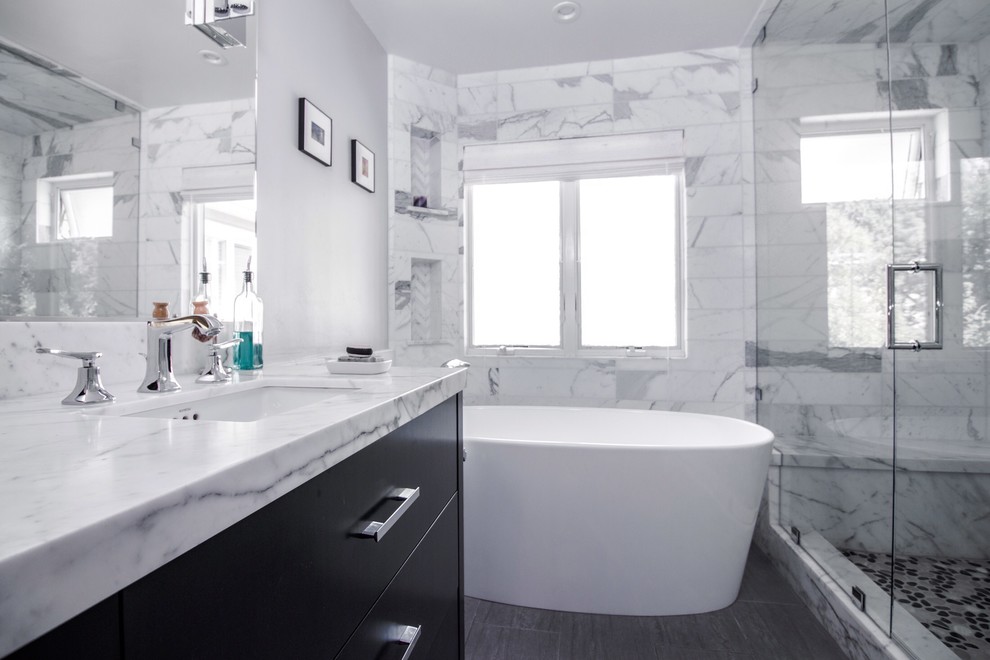 Design ideas for a medium sized modern ensuite wet room bathroom in San Francisco with flat-panel cabinets, black cabinets, a freestanding bath, a one-piece toilet, white tiles, stone tiles, grey walls, porcelain flooring, a submerged sink, marble worktops and white worktops.