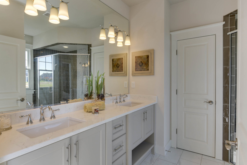 Exemple d'une petite salle de bain principale chic avec un placard à porte affleurante, des portes de placard grises, une douche d'angle, des carreaux de porcelaine, un mur blanc, un sol en marbre, un lavabo encastré et un plan de toilette en quartz modifié.