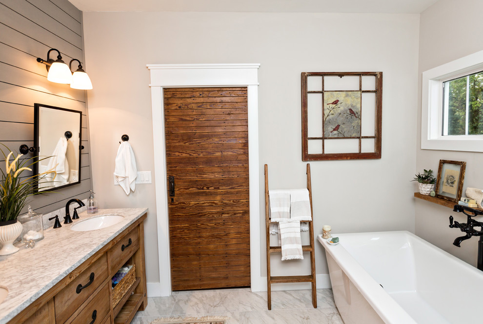 Immagine di una stanza da bagno country con ante con finitura invecchiata, vasca da incasso, doccia alcova, piastrelle grigie, piastrelle di marmo, pareti bianche, pavimento in marmo e pavimento bianco