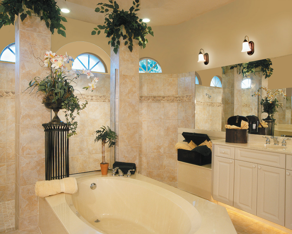 Exemple d'une grande salle de bain principale méditerranéenne avec un lavabo intégré, un placard avec porte à panneau surélevé, des portes de placard blanches, un plan de toilette en marbre, une baignoire posée, une douche double, un carrelage beige, des carreaux de céramique, un mur beige et un sol en carrelage de céramique.