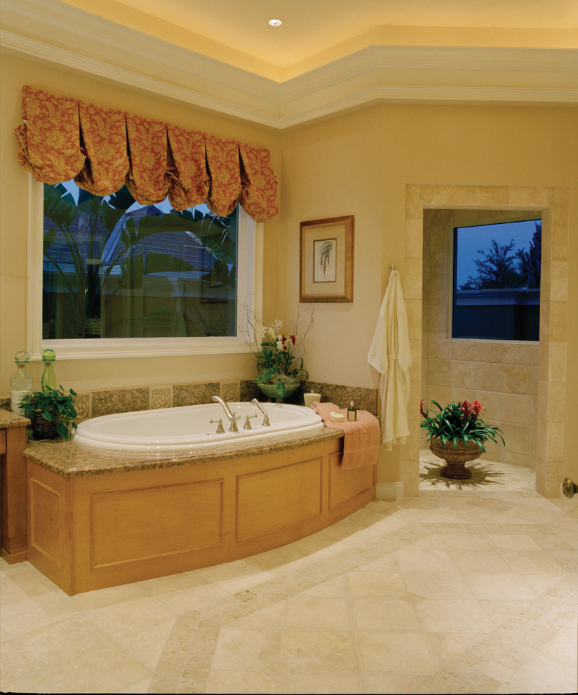 Large island style master beige tile and stone tile travertine floor bathroom photo in Miami with raised-panel cabinets, medium tone wood cabinets, a two-piece toilet, beige walls, an undermount sink and granite countertops
