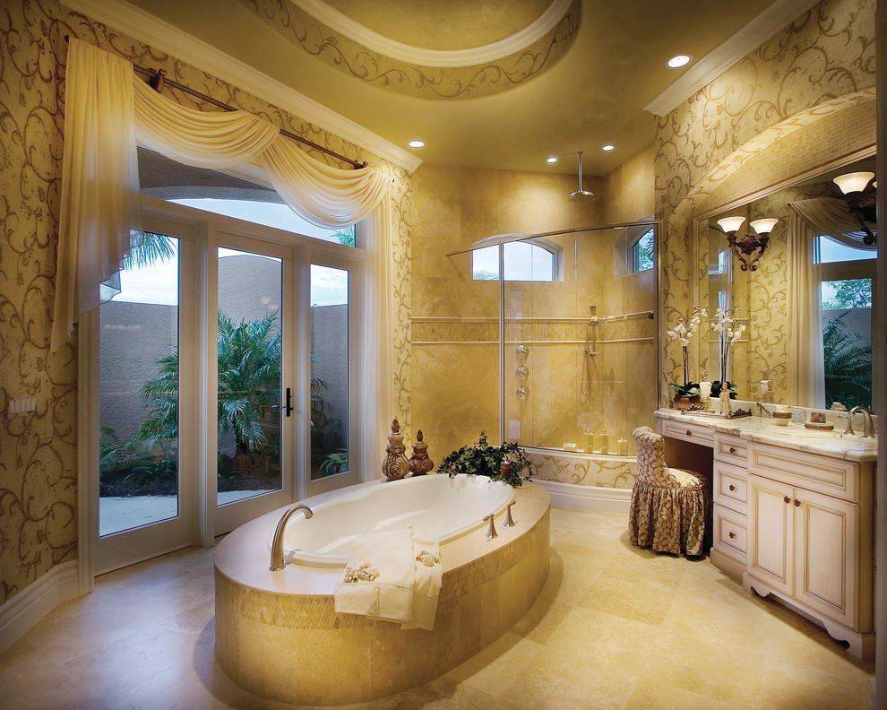 Design ideas for a large mediterranean ensuite bathroom in Miami with a submerged sink, raised-panel cabinets, white cabinets, marble worktops, a built-in bath, a corner shower, a two-piece toilet, beige tiles, stone tiles, beige walls and travertine flooring.