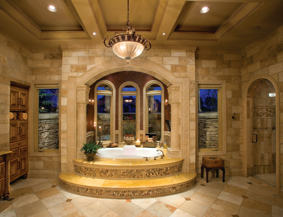 Bild på ett mycket stort medelhavsstil en-suite badrum, med luckor med upphöjd panel, skåp i mellenmörkt trä, granitbänkskiva, ett platsbyggt badkar, en dusch i en alkov, beige kakel, stenkakel, flerfärgade väggar och travertin golv