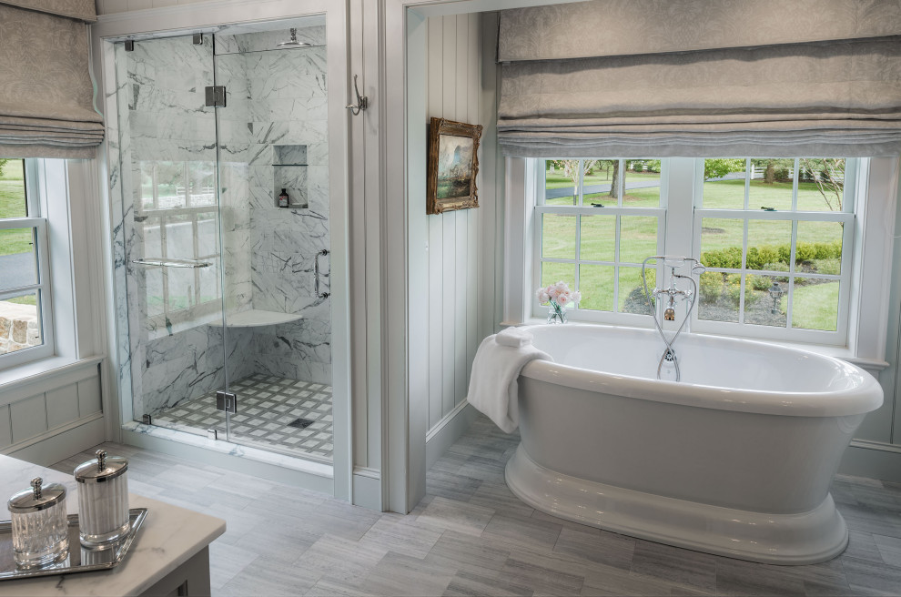 Traditional ensuite bathroom in Philadelphia with a freestanding bath, an alcove shower, white walls, marble flooring, marble worktops, grey floors, a hinged door, white worktops and white tiles.