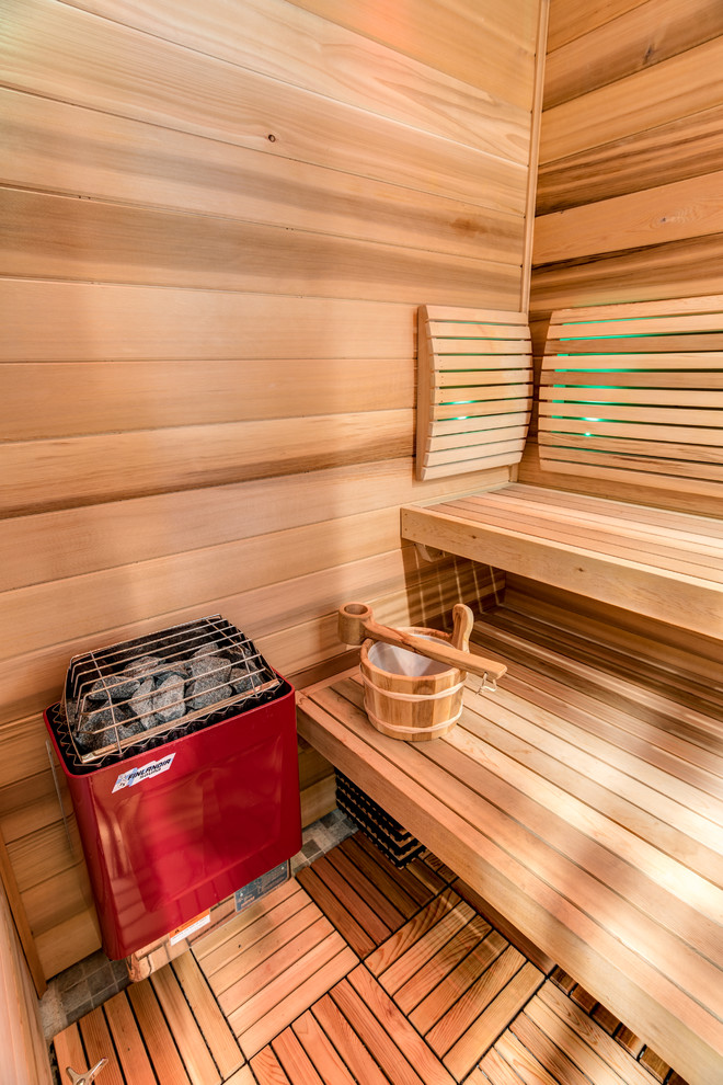 Inspiration pour un grand sauna chalet en bois clair avec un placard à porte shaker, une baignoire indépendante, une douche ouverte, WC à poser, un carrelage gris, des carreaux de béton, un mur gris, carreaux de ciment au sol, un lavabo encastré, un plan de toilette en granite, un sol gris et une cabine de douche à porte coulissante.