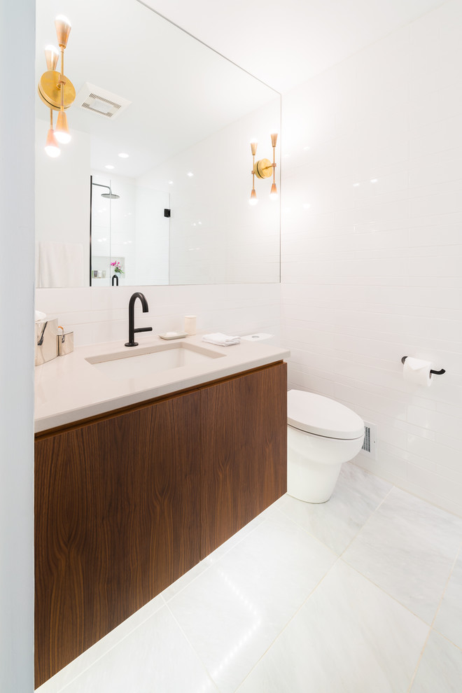 This is an example of a large contemporary ensuite bathroom in Bridgeport with a one-piece toilet, white walls, ceramic flooring, flat-panel cabinets, dark wood cabinets, an alcove shower, a submerged sink, quartz worktops, white tiles and metro tiles.