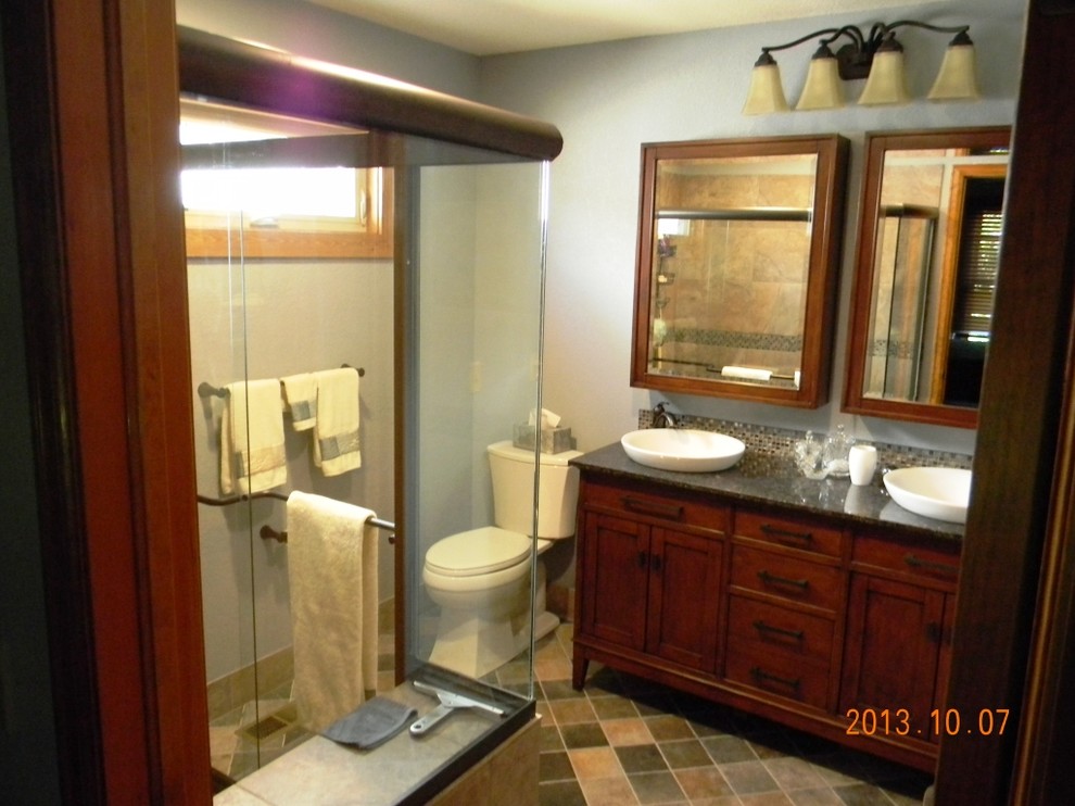 Design ideas for a medium sized contemporary ensuite bathroom in Denver with freestanding cabinets, medium wood cabinets, a walk-in shower, a two-piece toilet, multi-coloured tiles, glass sheet walls, grey walls, mosaic tile flooring, a vessel sink and engineered stone worktops.
