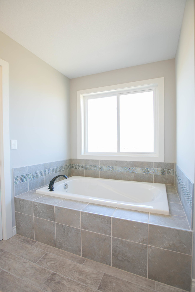 Immagine di una stanza da bagno padronale chic con consolle stile comò, vasca idromassaggio, doccia aperta, piastrelle grigie, lastra di vetro e pareti grigie