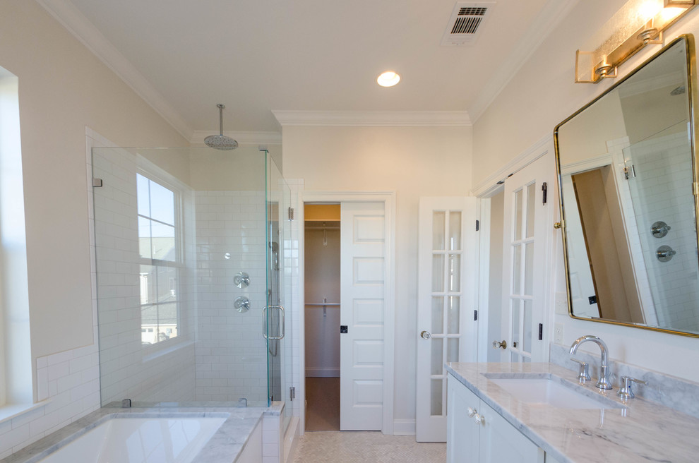 На фото: главная ванная комната среднего размера в классическом стиле с плоскими фасадами, белыми фасадами, полновстраиваемой ванной, открытым душем, бежевой плиткой, врезной раковиной и мраморной столешницей с